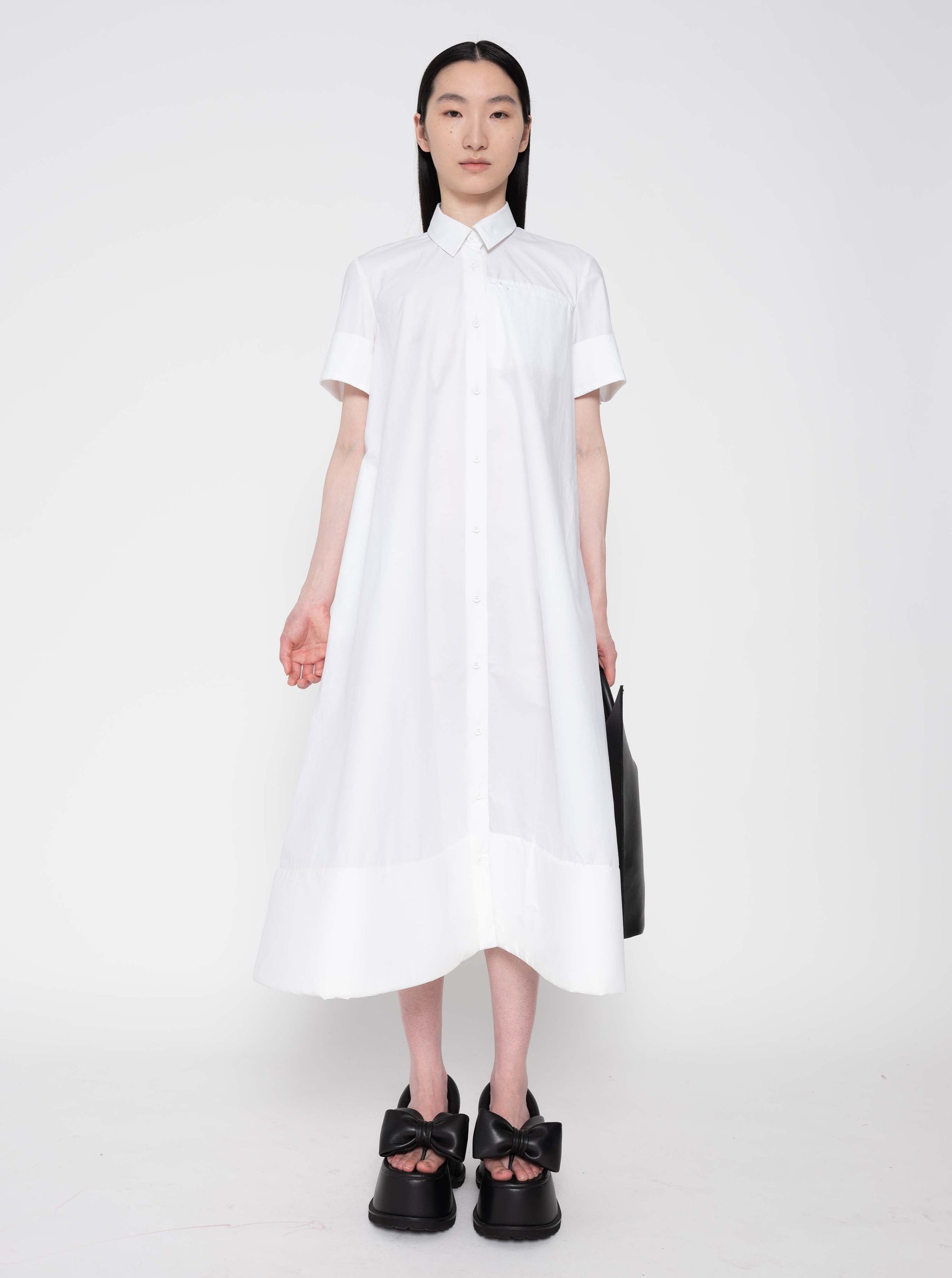 FRONT-VIEW-BRUNETTE-WOMAN-white-a-line-shaped-cotton-dress-with-foam-hem-detail-WEARING-BOW-PLATFORM-SANDALS-IN-BLACK