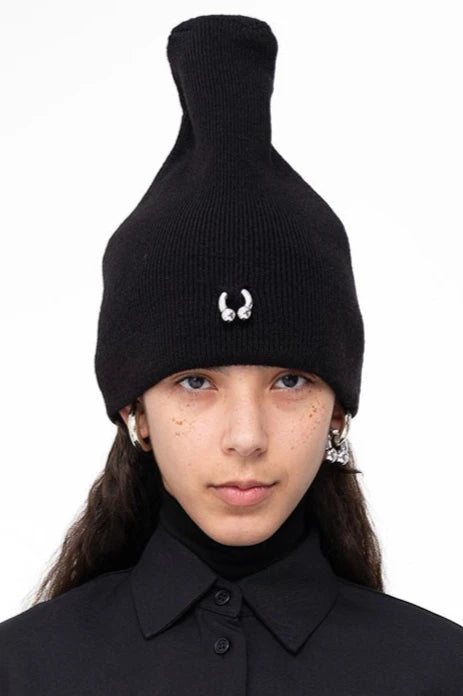 female-wearing-black-beanie-with-piercing-detail-on-white-background-face-closeup