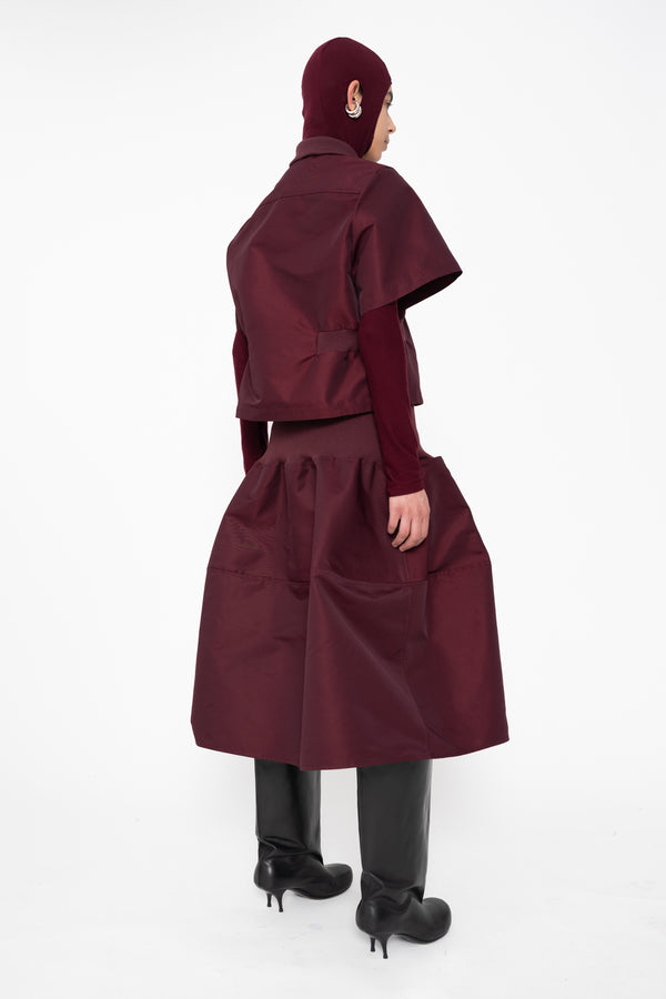 female-wearing-cropped-bordeaux-bomber-shirt-with-midi-skirt-in-same-bordeaux-color-with-bordeaux-balaclava-turtleneck-on-white-background-full-body-back-side