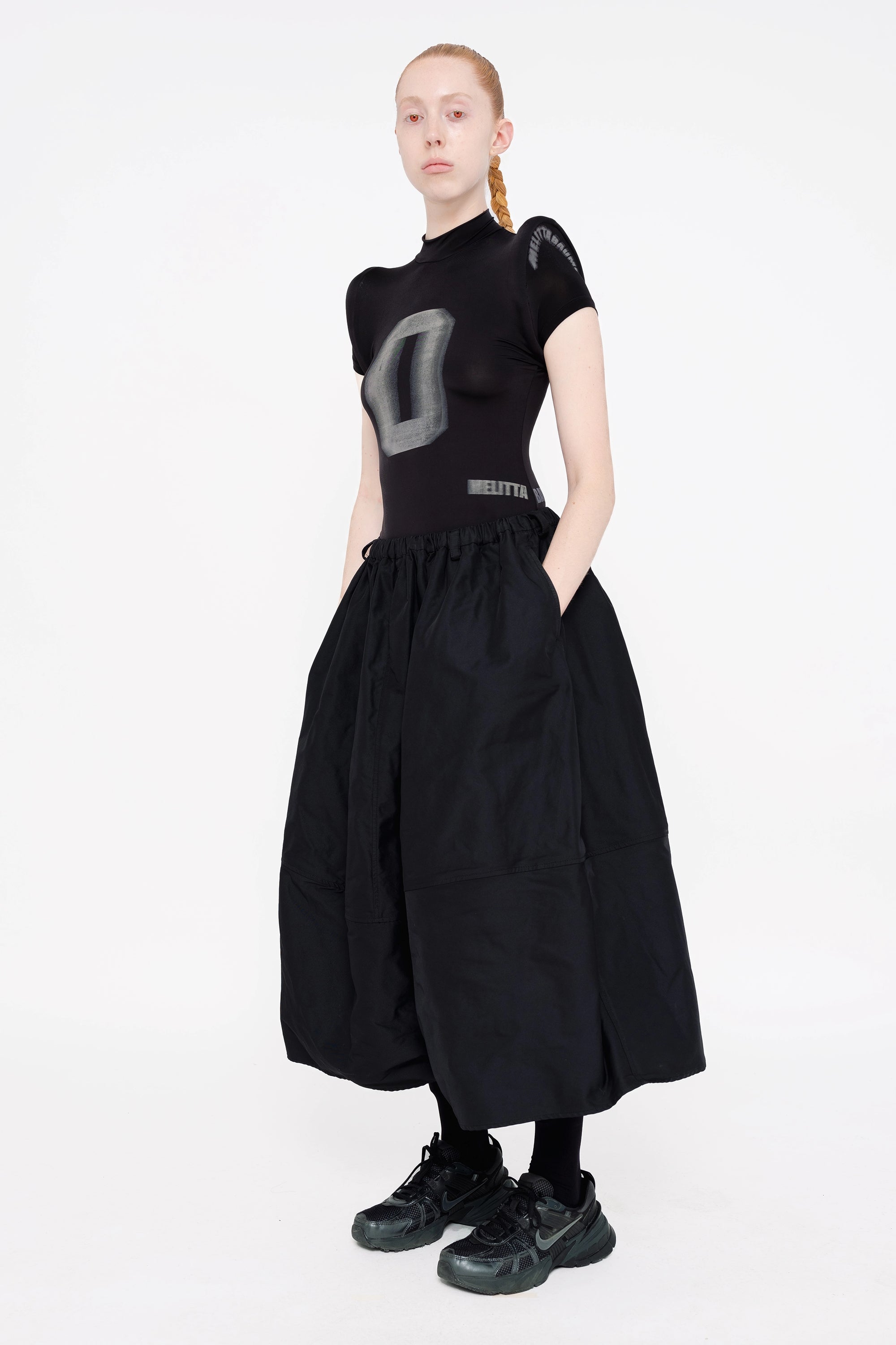 female-wearing-black-spongy-shoulder-top-and-black-maxi-volume-skirt-on-white-background-full-body-three-quarter