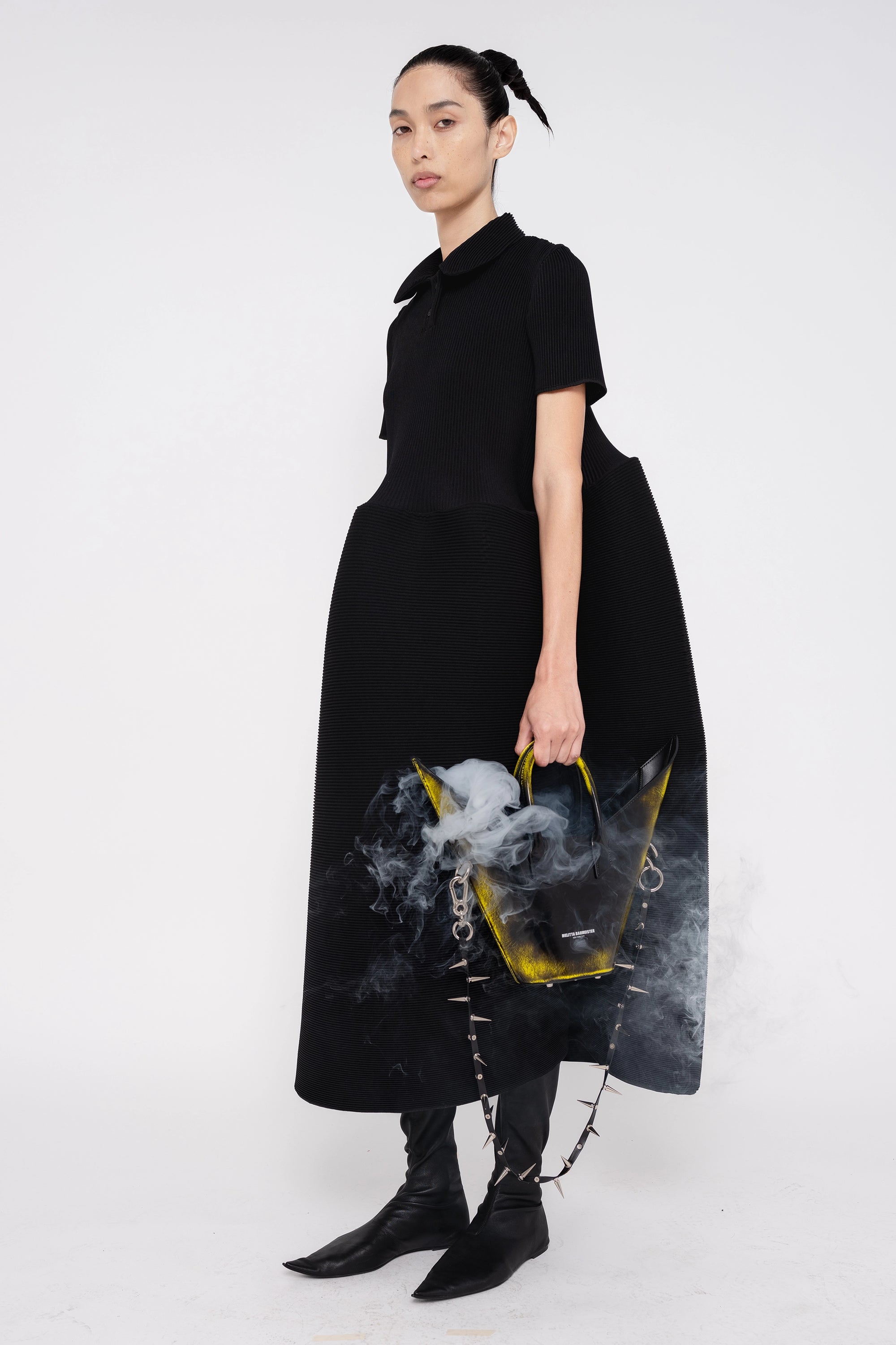 female-wearing-black-pleated-dress-with-polo-collar-and-ruffled-skirt-on-white-background-full-body-three-quarter