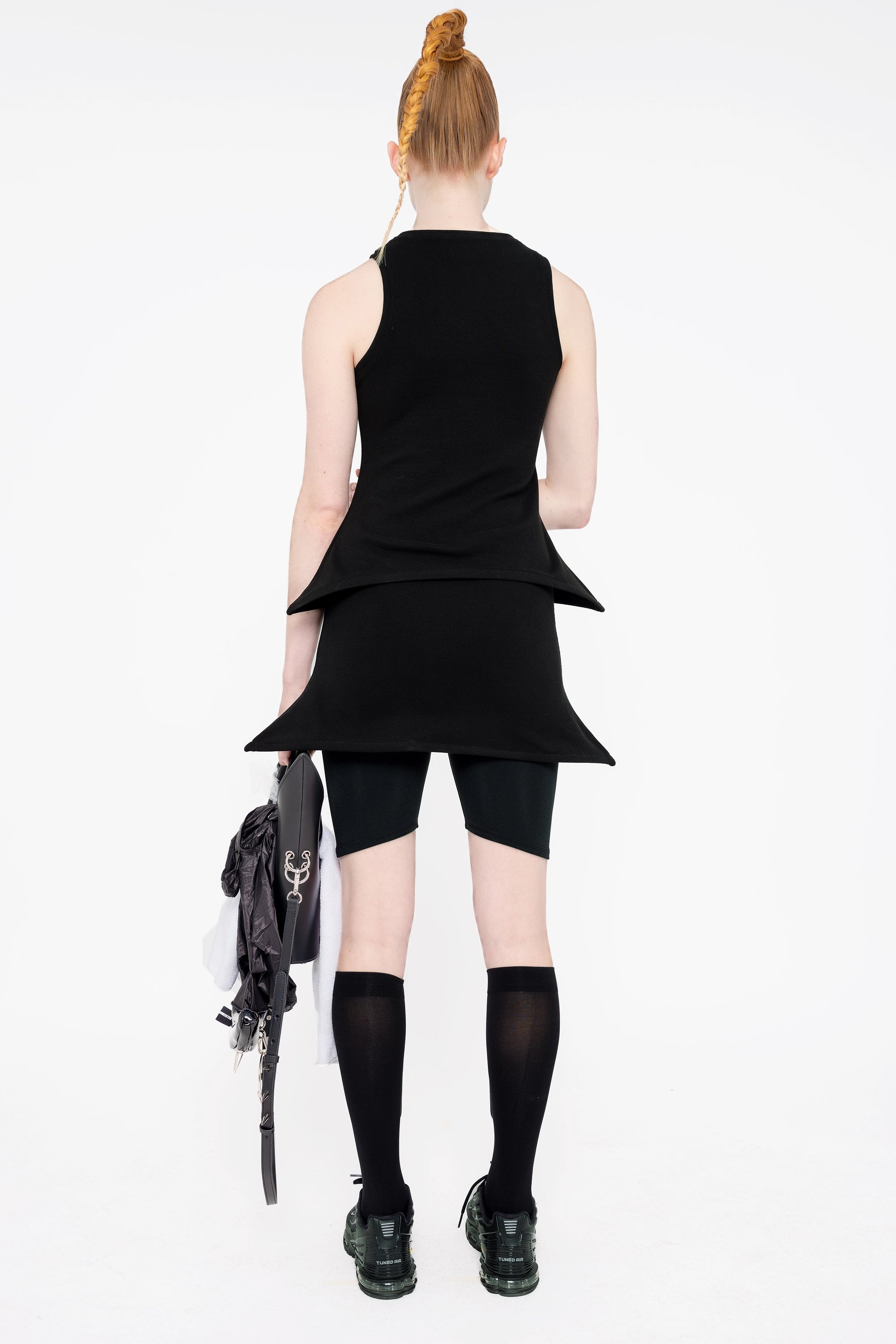 female-wearing-black-tank-top-with-pointy-hem-with-black-mini-skirt-with-pointy-hem-on-white-background-full-body-back